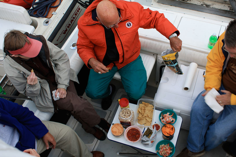 Photo: Boaters relax in cockpit with generous snacks.