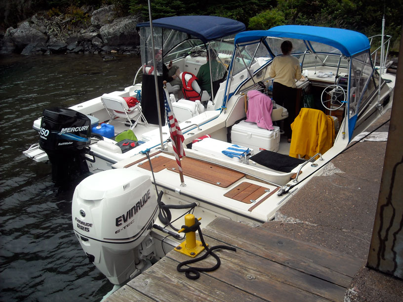 Photo: Two Boston Whaler boats moored to the old boat house in the cove at Passage Island, Lake Superior