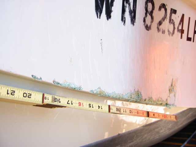 Photo: Ruler laid on hull to show damage length