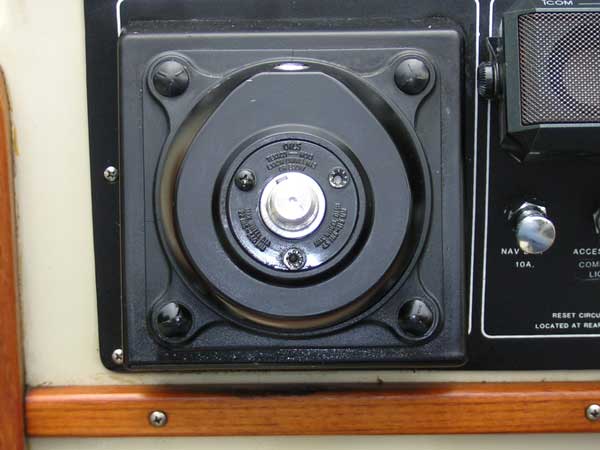 [Photo: Close-up of helm pump showing seal cover plate in place]